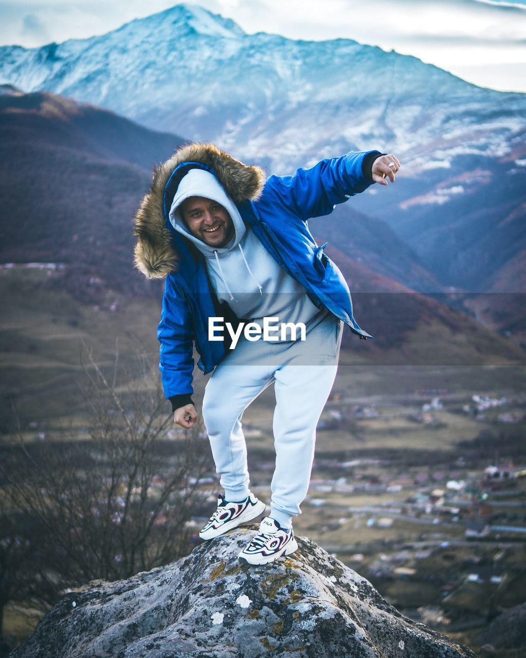 Full length of man standing on rock against mountains