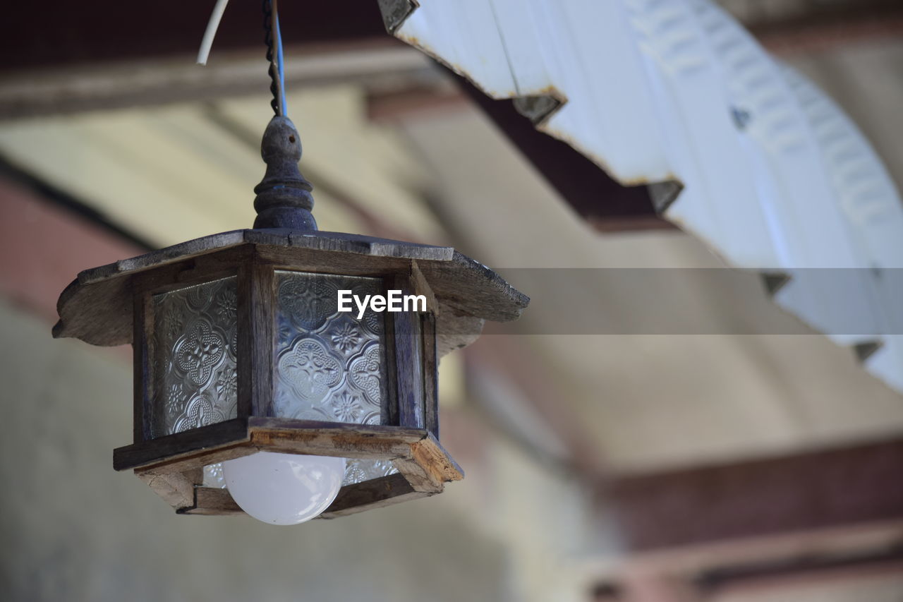 LOW ANGLE VIEW OF LANTERN HANGING IN BUILDING