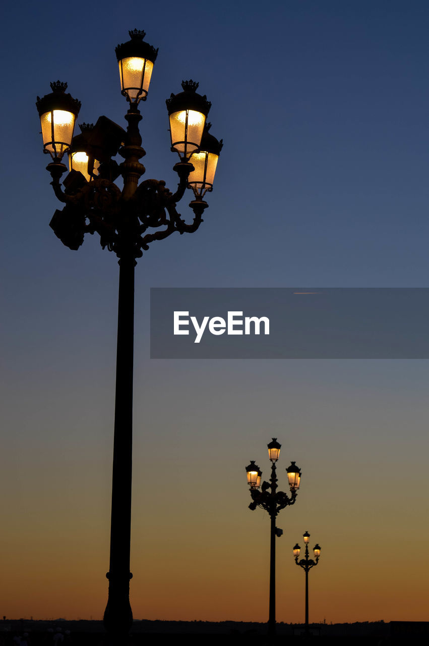 Low angle view of illuminated street light against clear sky