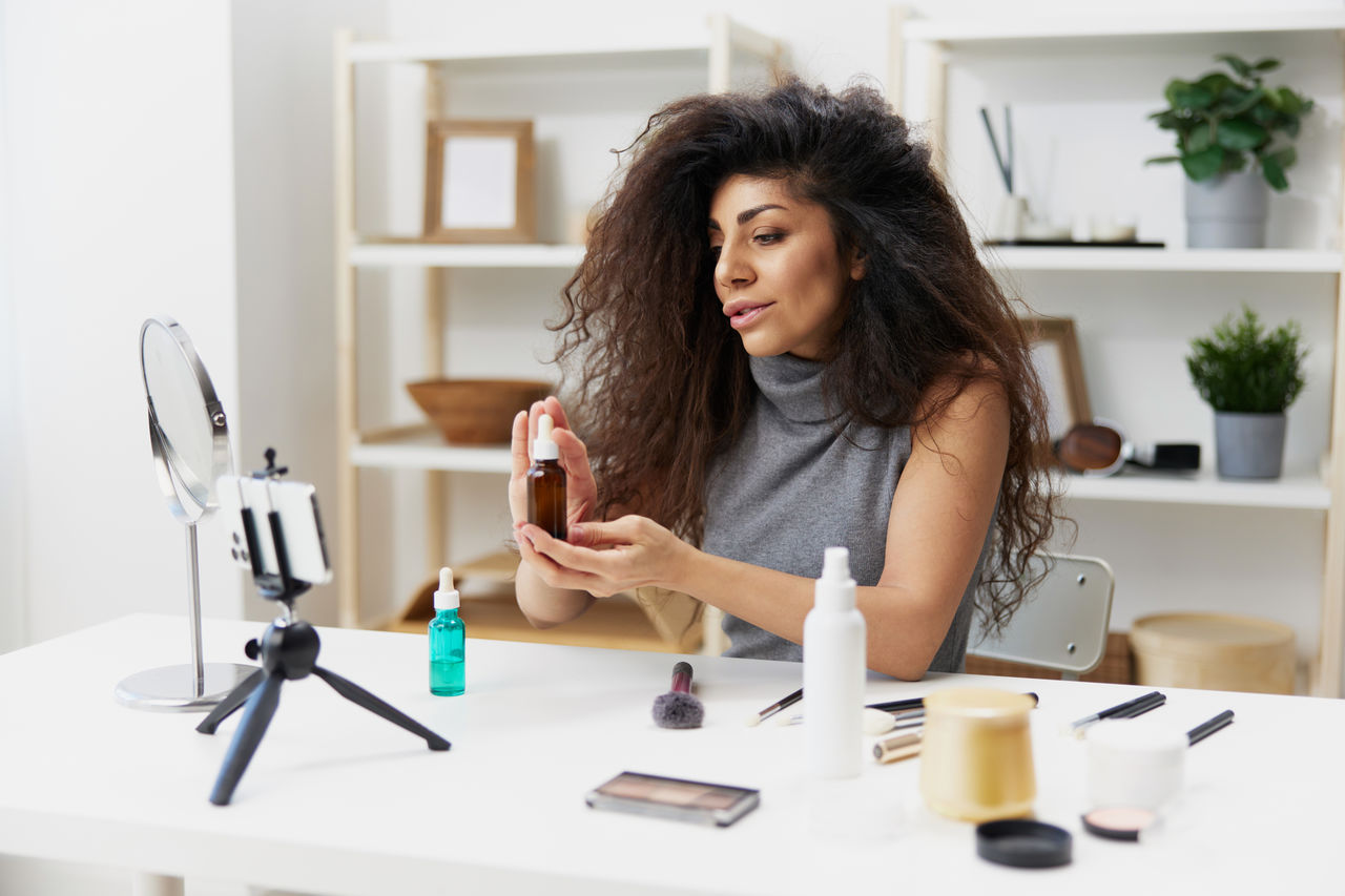 young woman using mobile phone while sitting at table