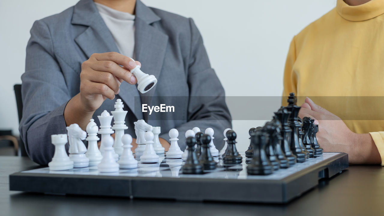 midsection of businessman playing chess in gym