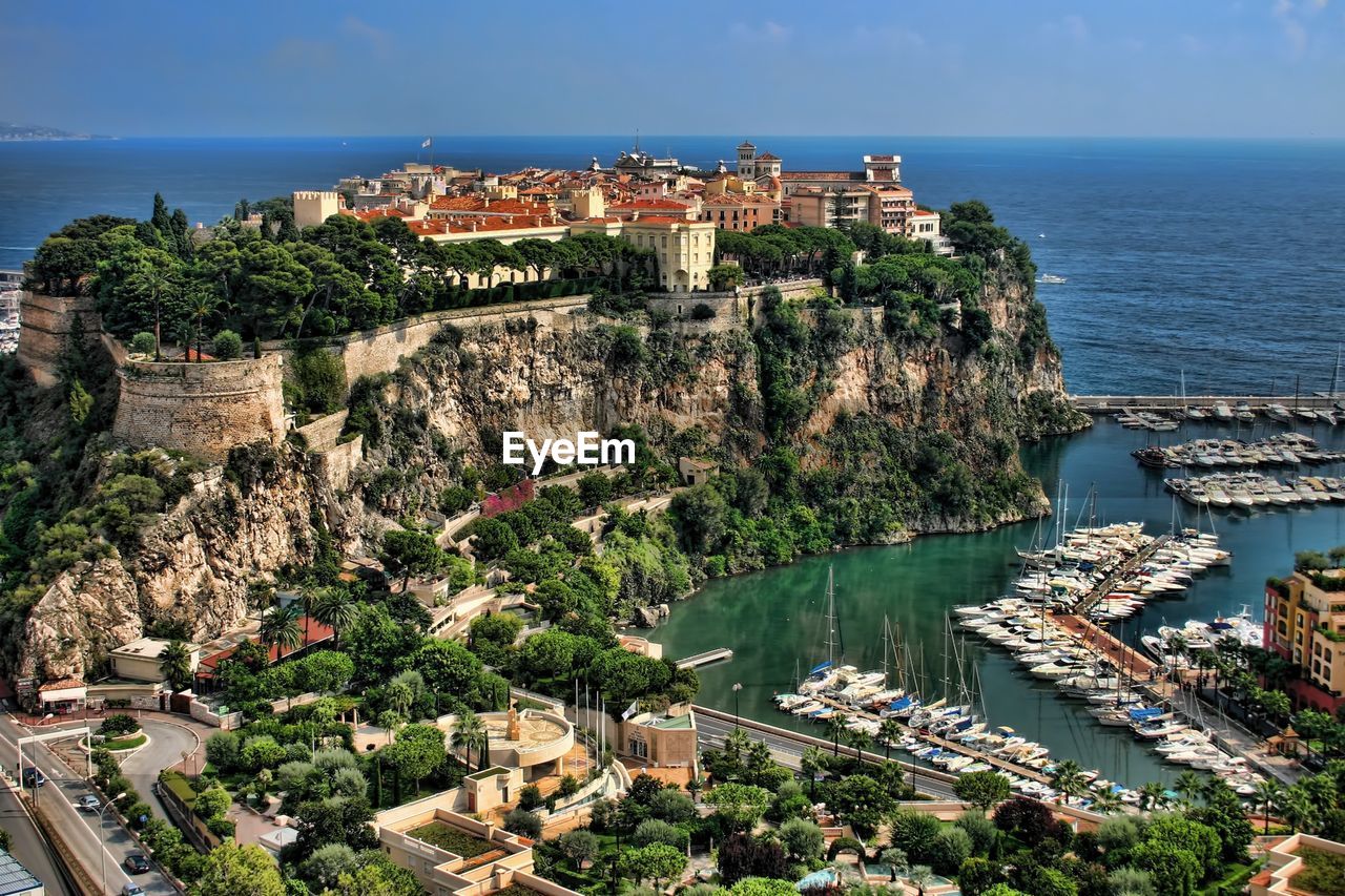 Houses on top of hill by harbor