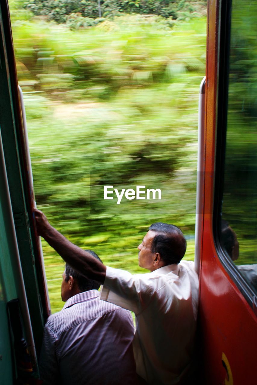 MAN SITTING BY TRAIN WINDOW