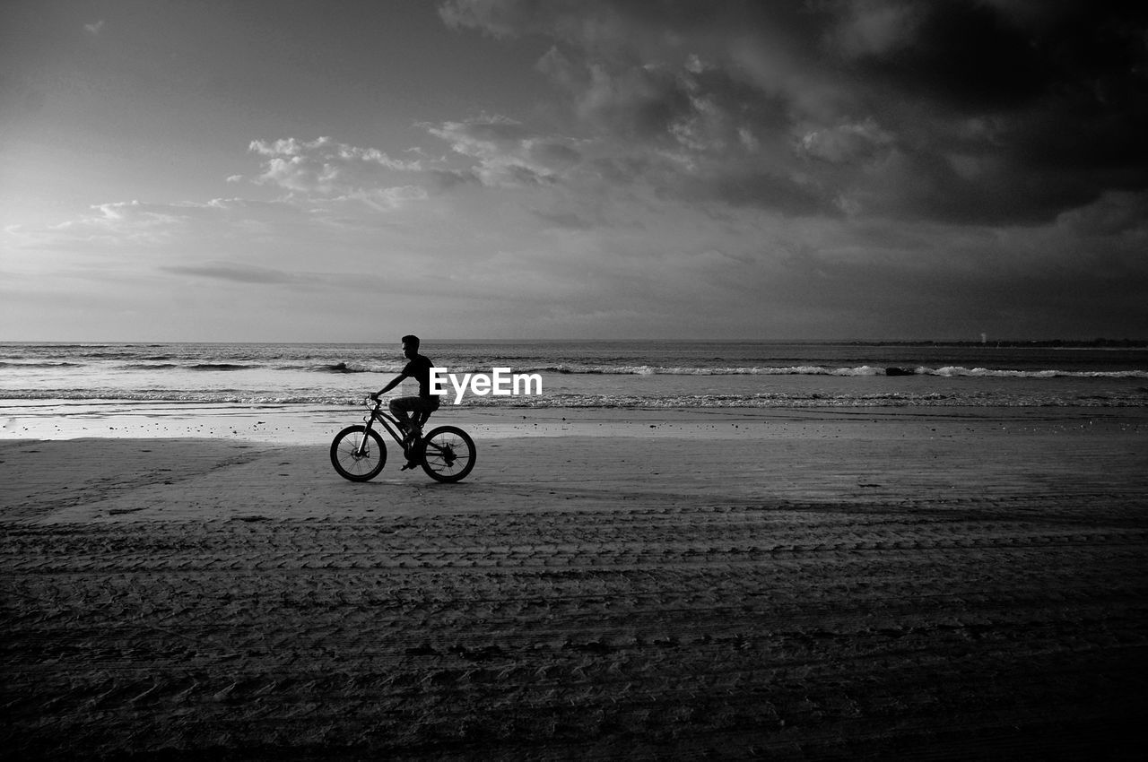Man riding bicycle at beach