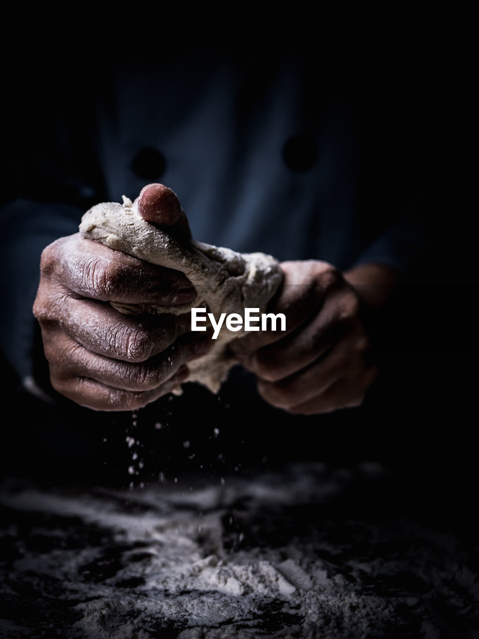 Close-up of man kneading dough