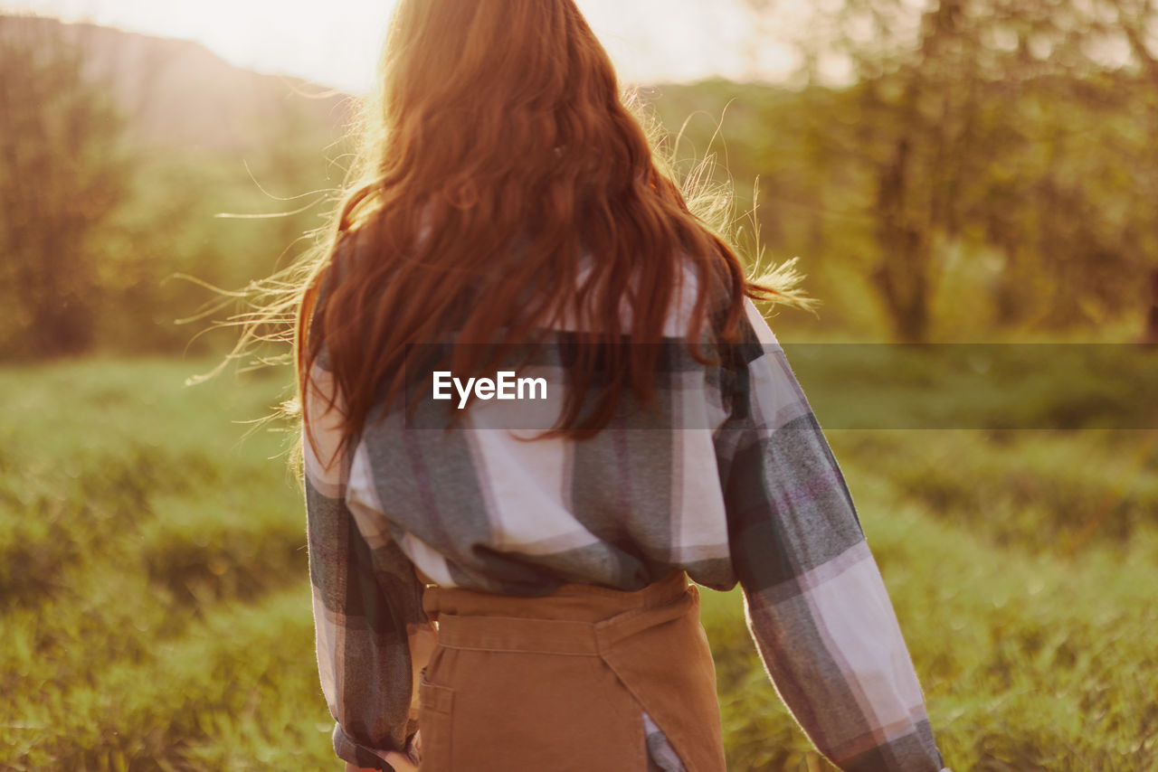 Rear view of woman standing on field