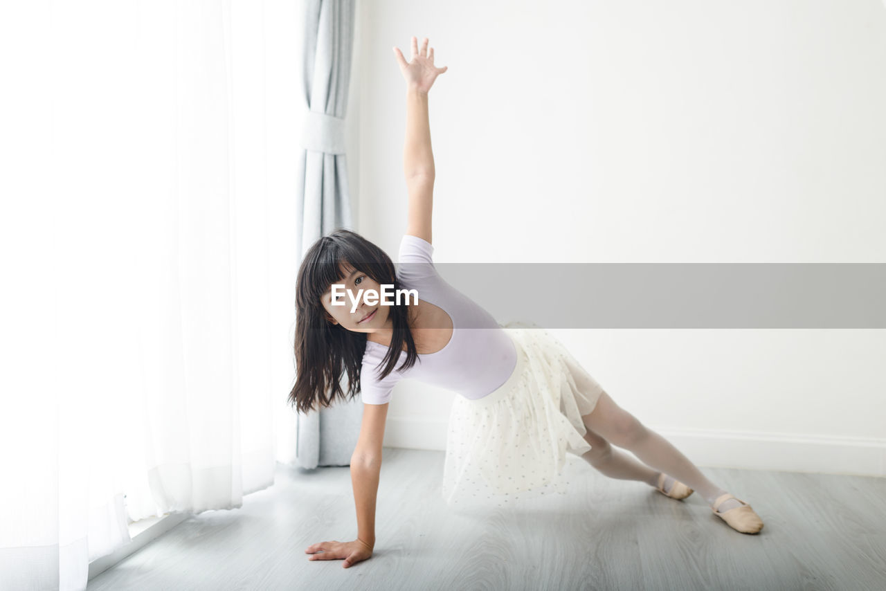 Full length of girl doing ballet dance at home