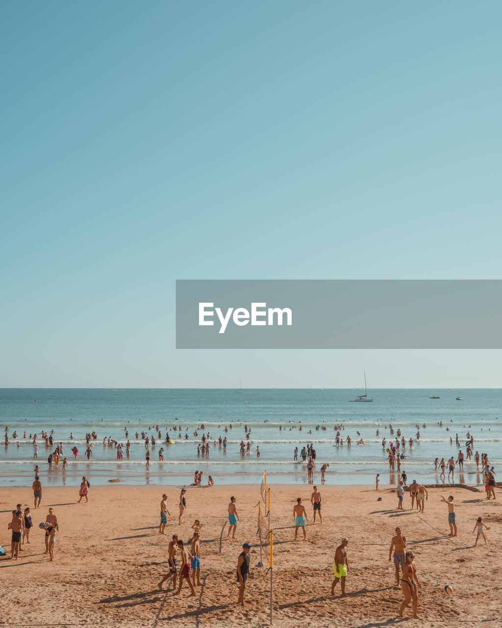 People at beach against clear sky