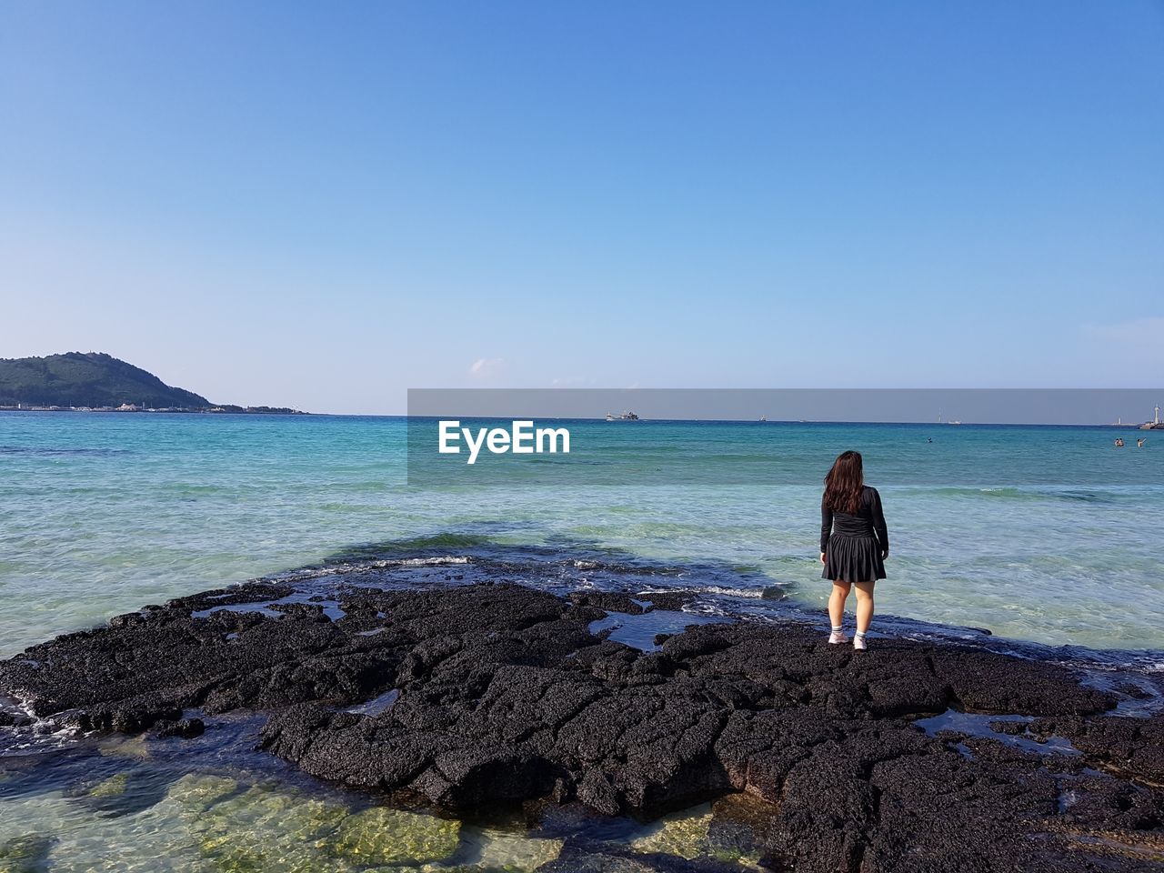 REAR VIEW OF WOMAN ON BEACH