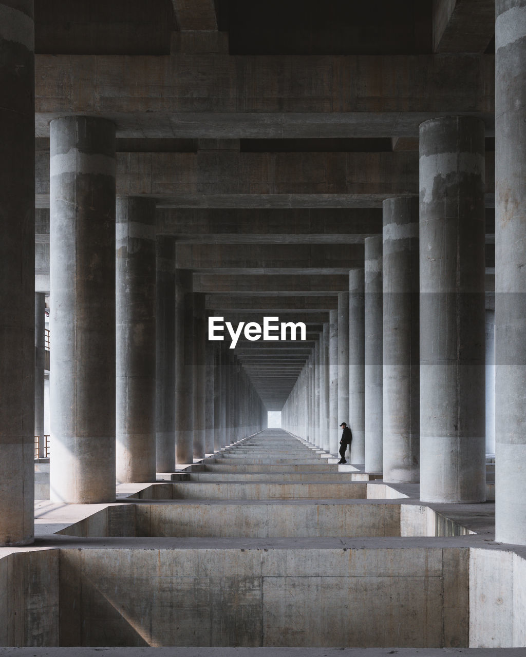 Man standing under bridge