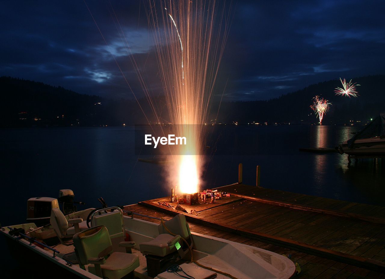 High angle view of firework exploding on pier at night