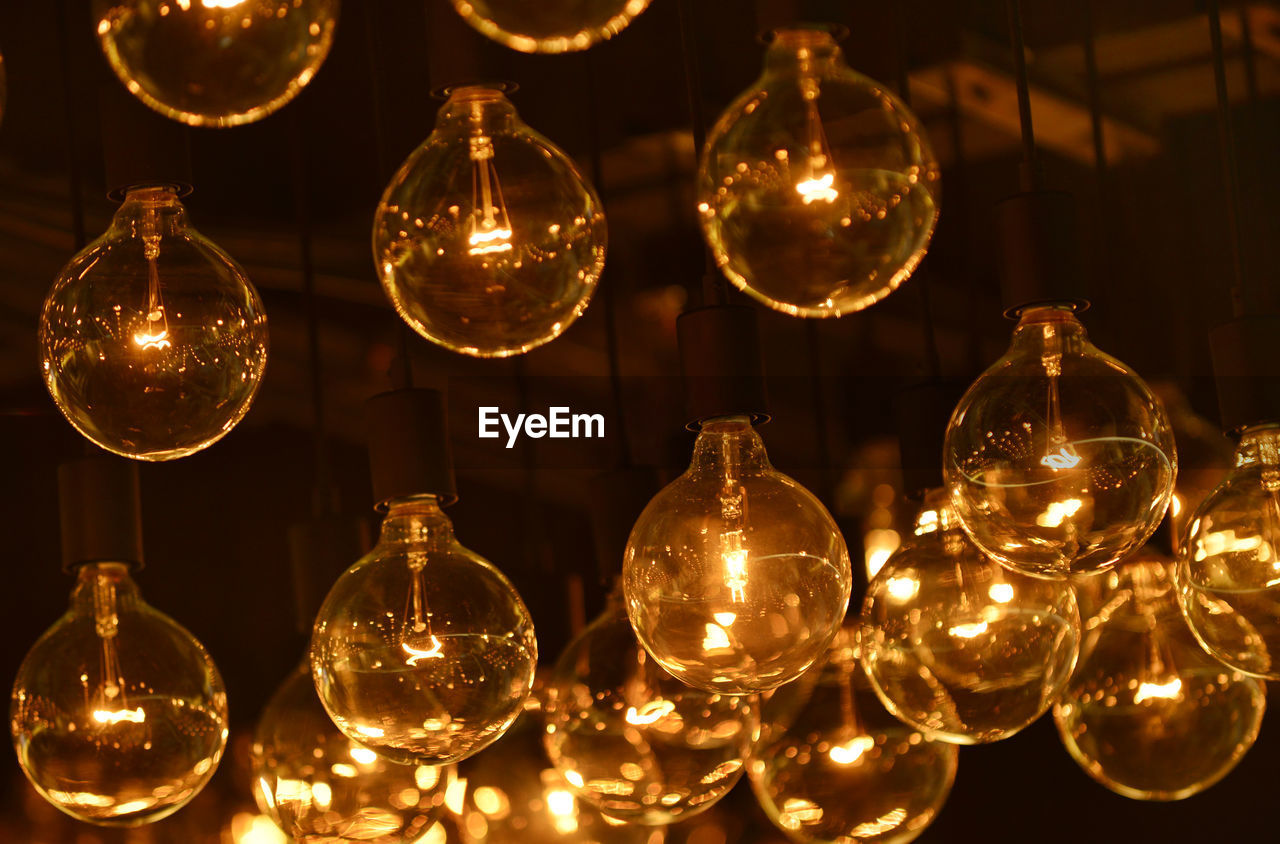 Low angle view of illuminated light bulb hanging