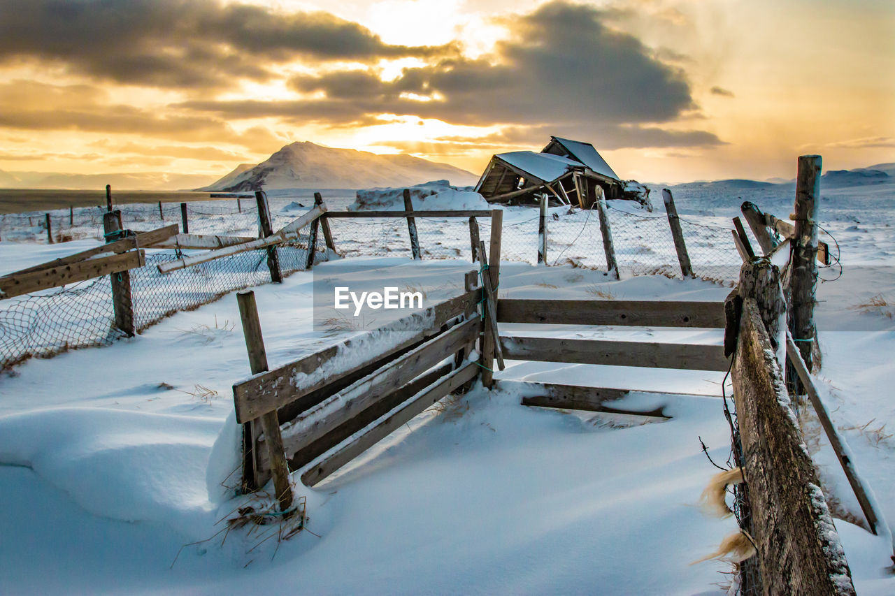 Scenic view of snow covered land against sky during sunset