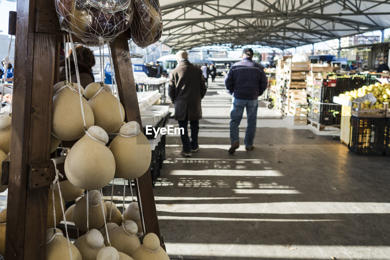 Rear view of men walking at market