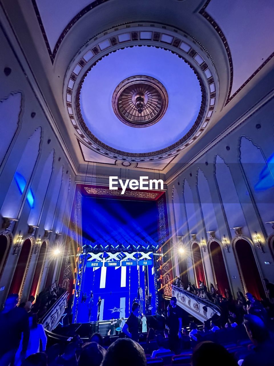 stage, crowd, group of people, architecture, arts culture and entertainment, large group of people, theatre, indoors, ceiling, illuminated, blue, lighting equipment, built structure, music, auditorium, event, night