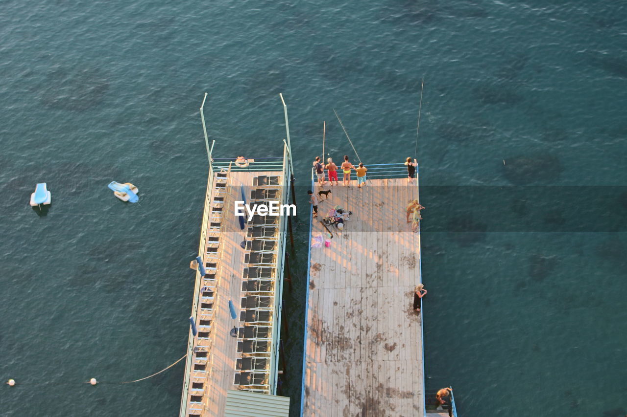 High angle view of people standing on jetty over sea