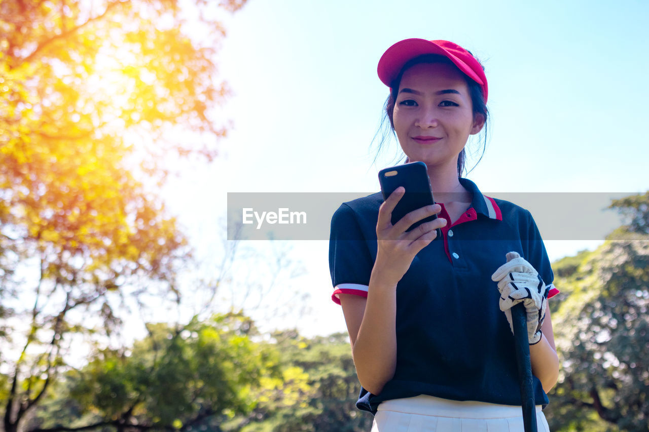 Full length of young woman using mobile phone