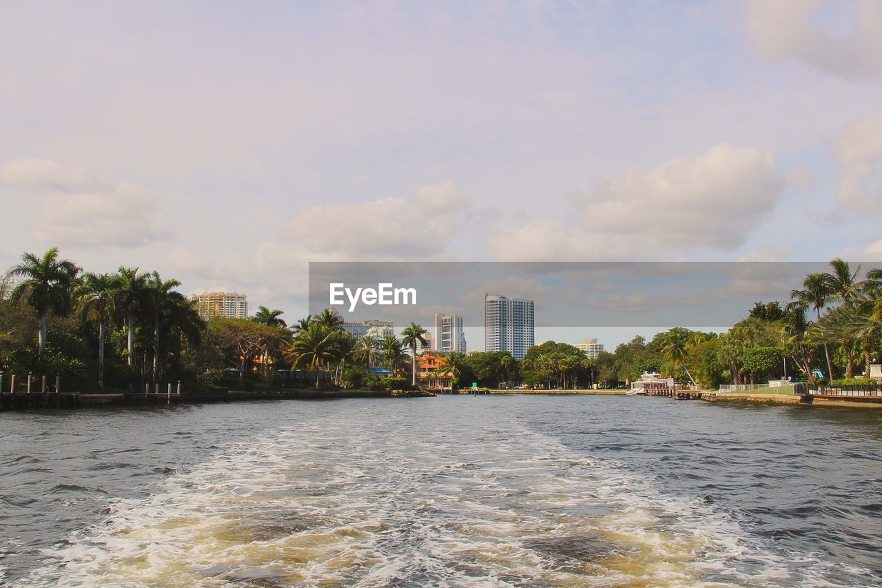 Scenic view of sea by buildings against sky