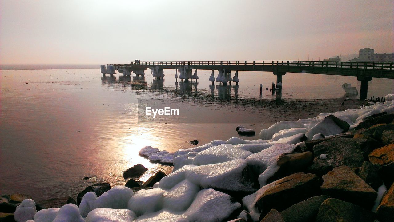 Bridge over calm sea and against clear sky