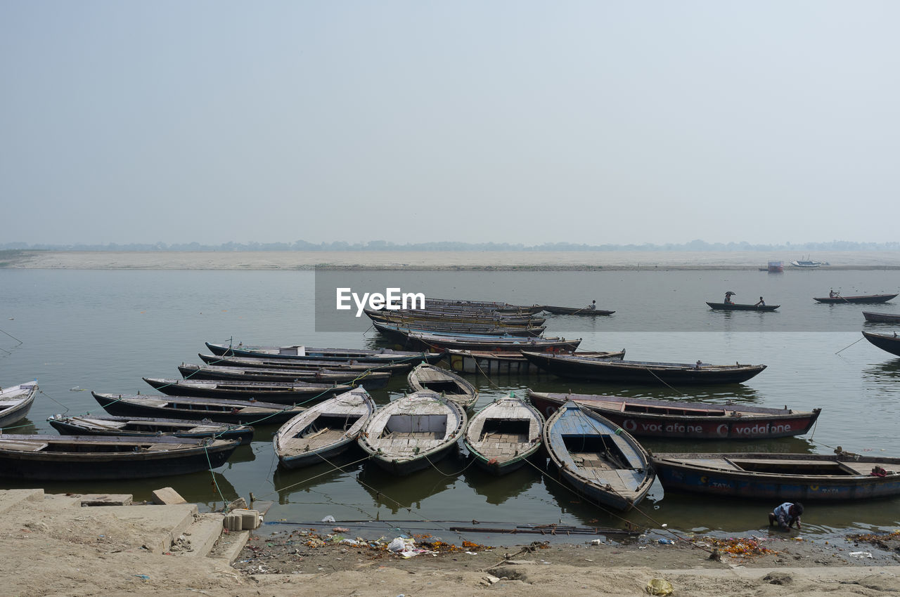 Boats moored on sea against clear sky