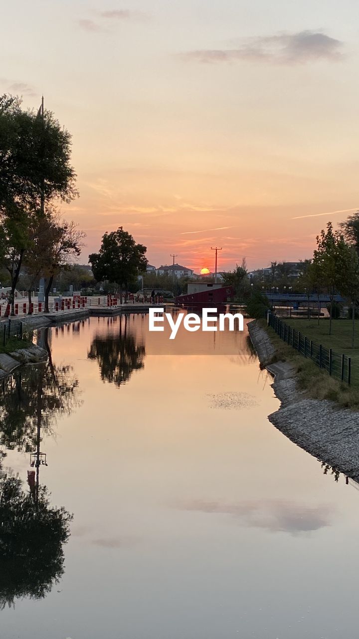 SCENIC VIEW OF RIVER BY TREES AGAINST SKY DURING SUNSET