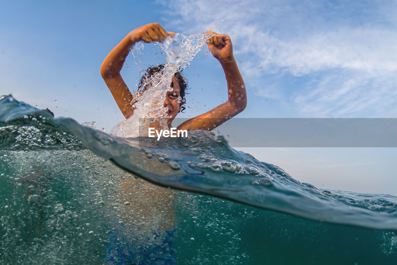 Woman swimming in sea against sky