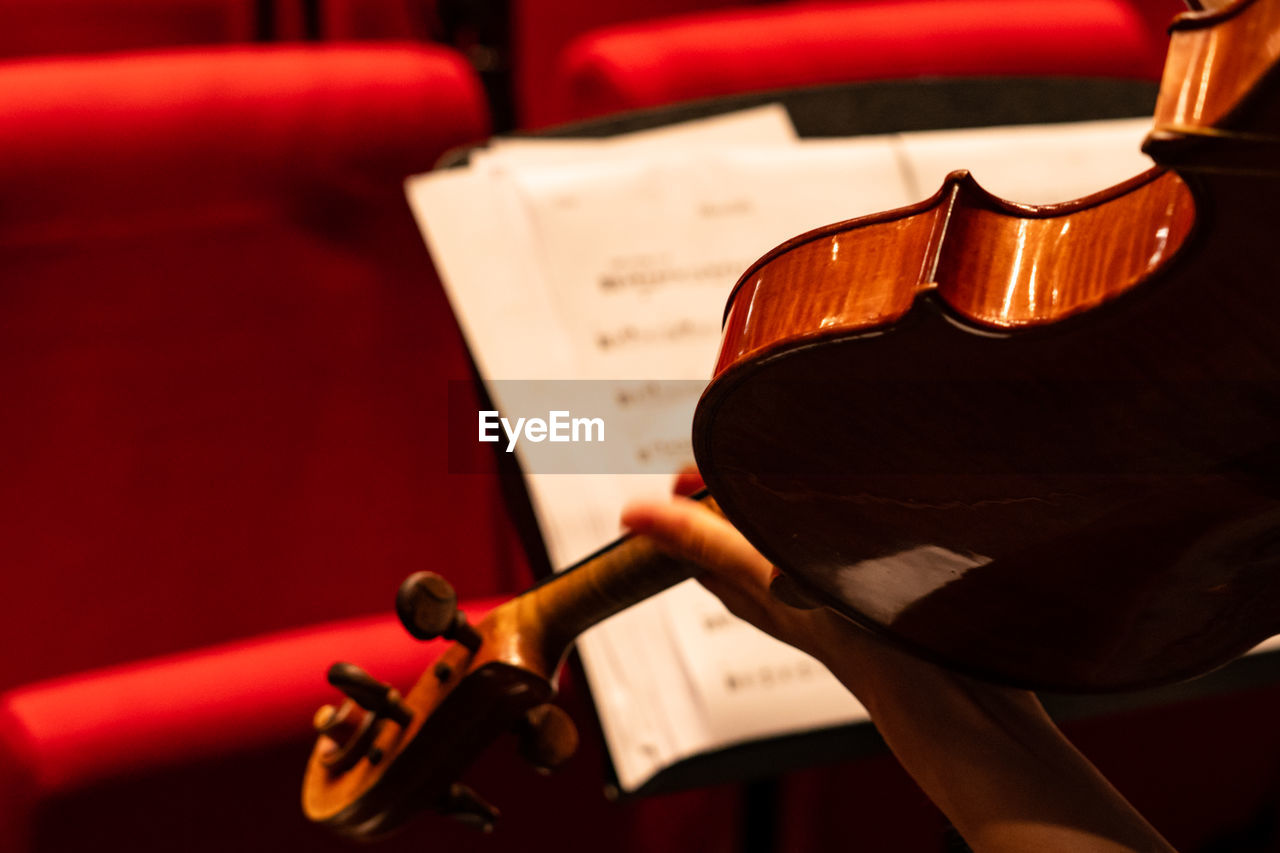 Midsection of person playing violin during orchestra