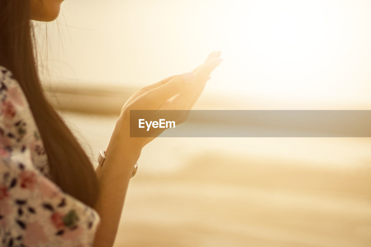 Woman praying hand on sunset