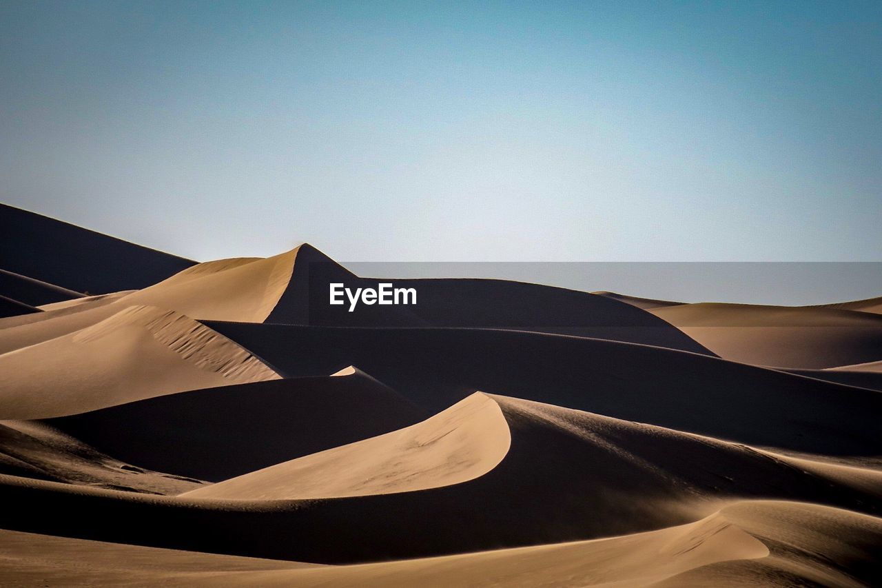 Low angle view of desert against clear sky