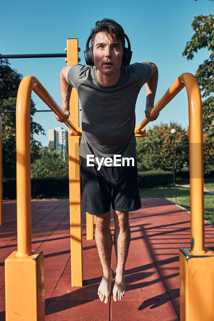 Young man doing dips on parallel bars during his workout in a modern calisthenics street workout