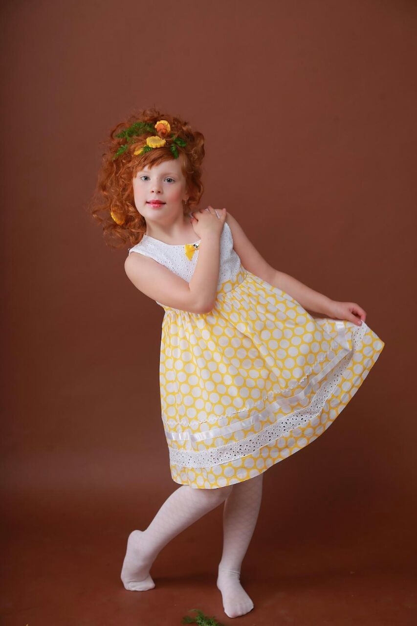 Portrait of girl in dress dancing against brown background