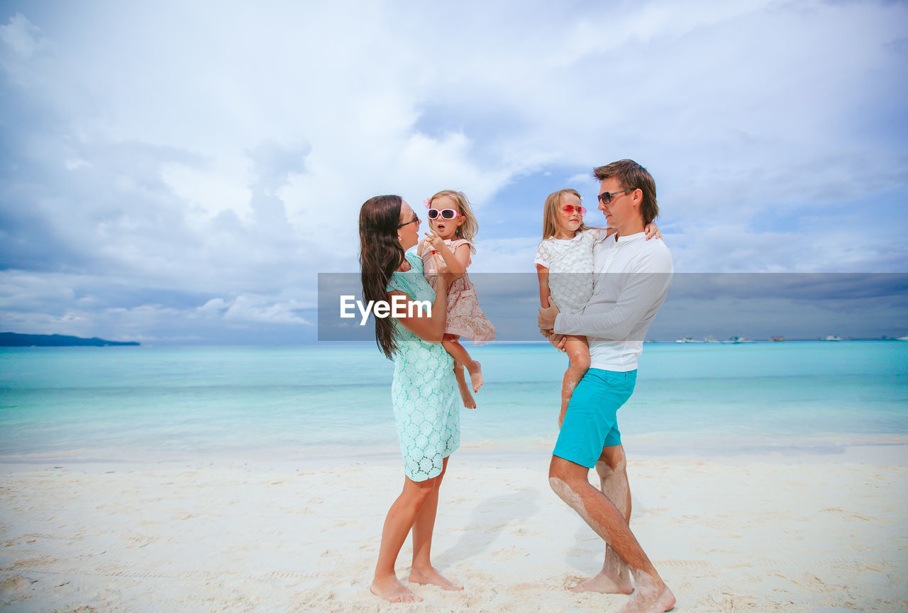 Parents with daughters standing on beach