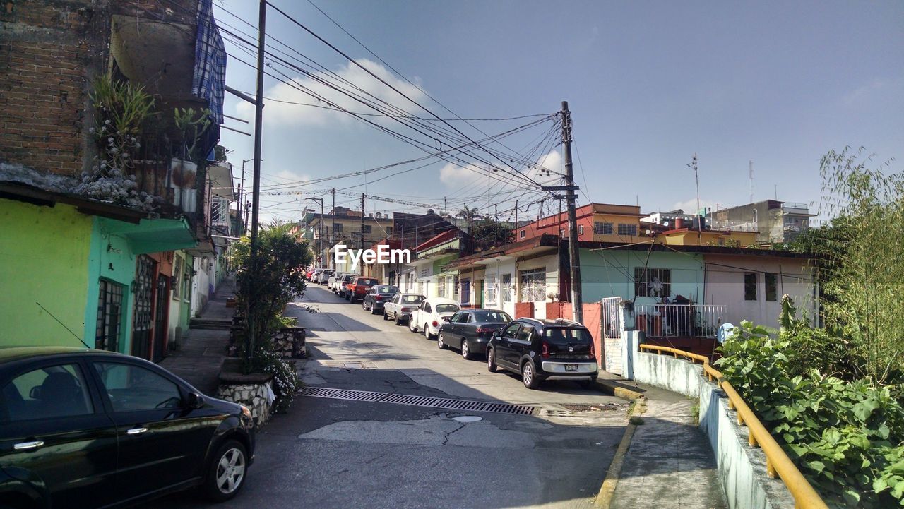 Cars on road in city against sky