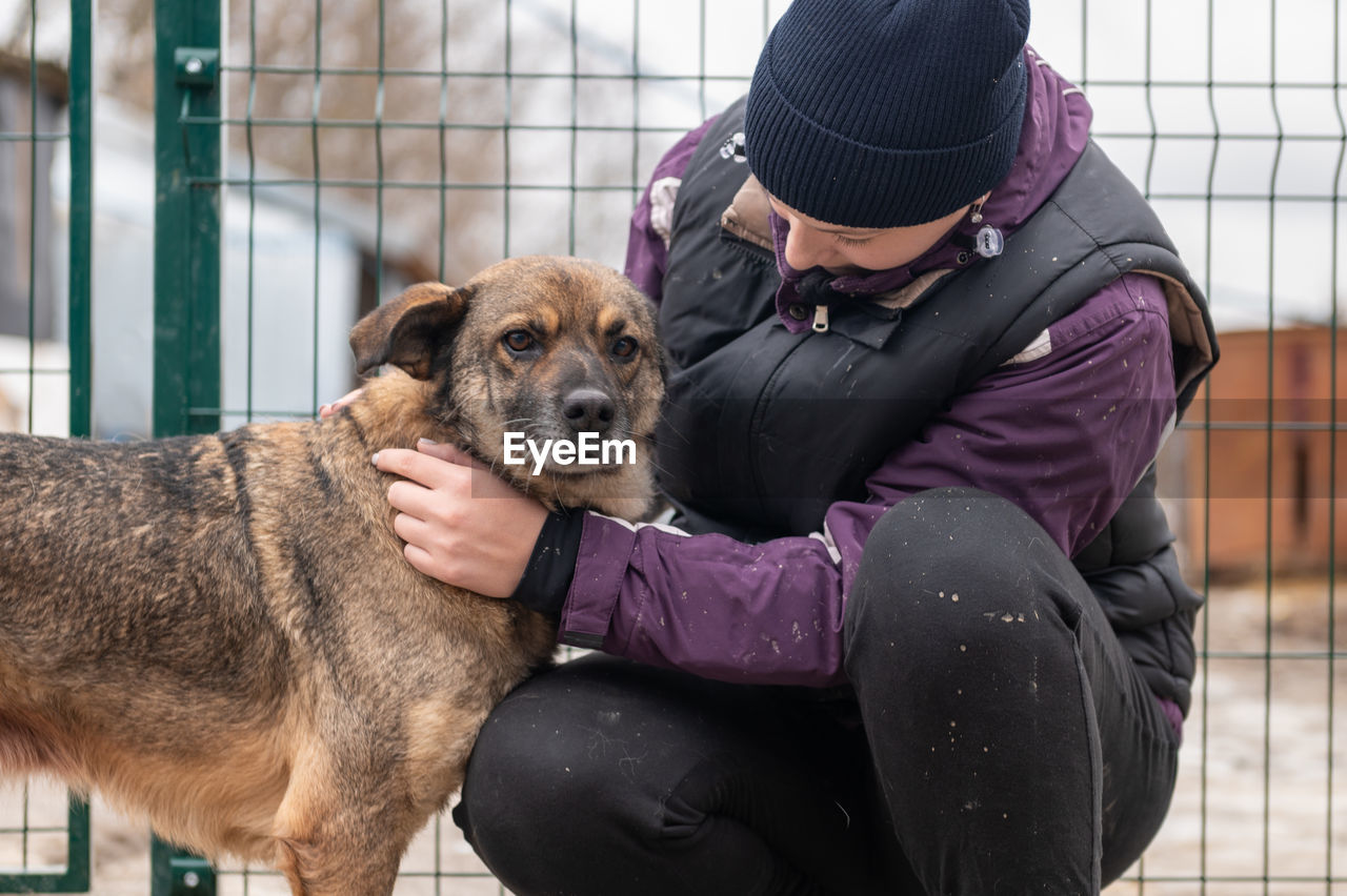 Girl volunteer in the nursery for dogs. shelter for stray dogs.