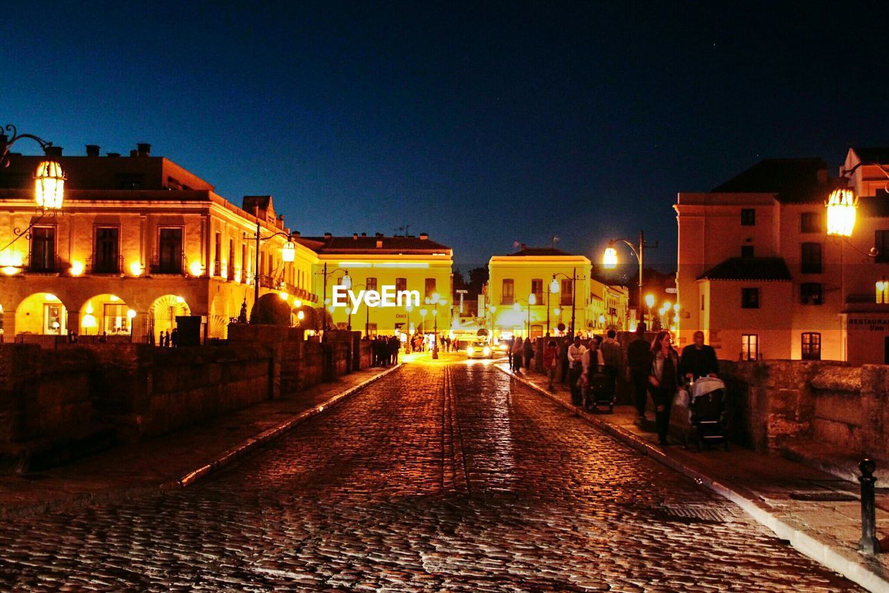 VIEW OF ILLUMINATED CITY AT NIGHT