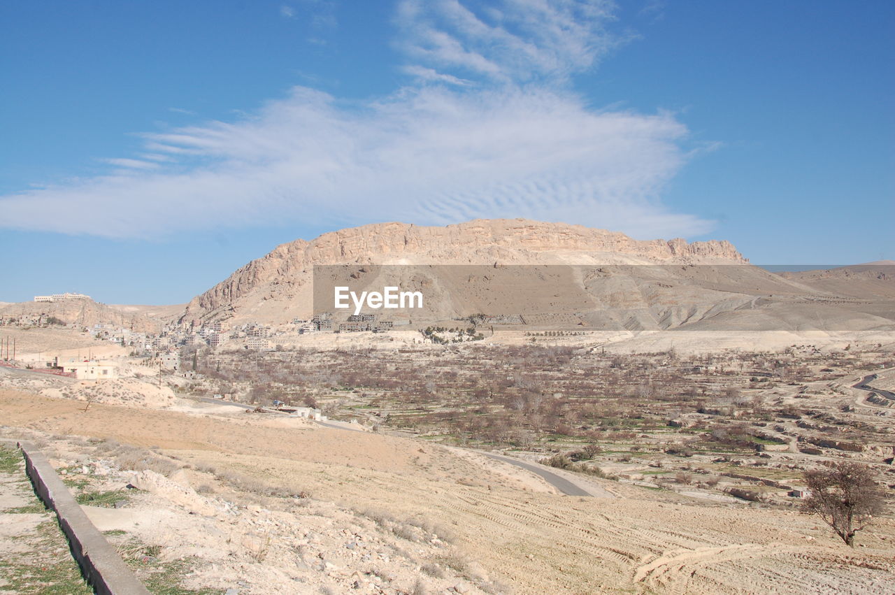 Scenic view of desert against blue sky