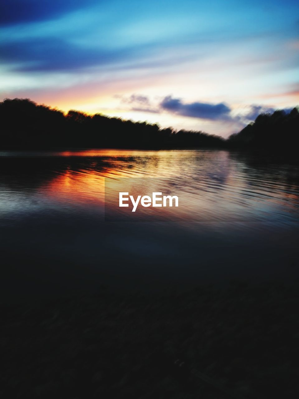 VIEW OF LAKE AGAINST CLOUDY SKY