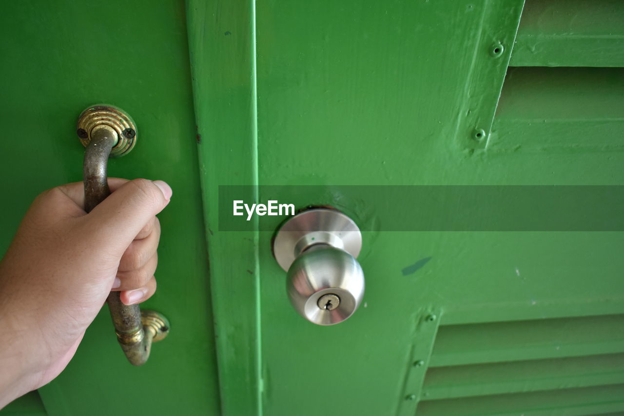 Cropped hand holding door handle