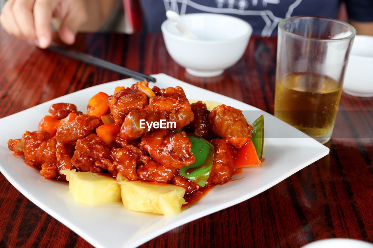 CLOSE-UP OF HAND HOLDING BOWL OF FOOD