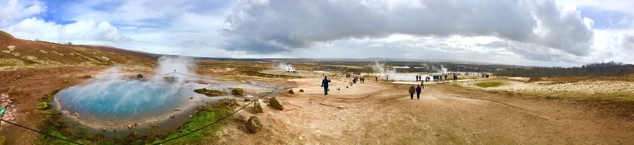 PANORAMIC SHOT OF PEOPLE ON LANDSCAPE AGAINST SKY