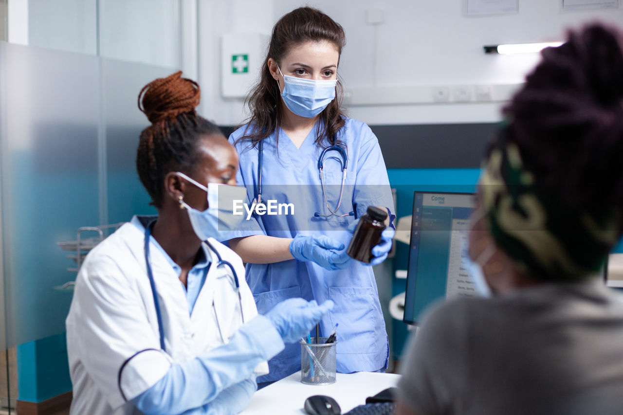 female doctor giving medicine to patient at clinic