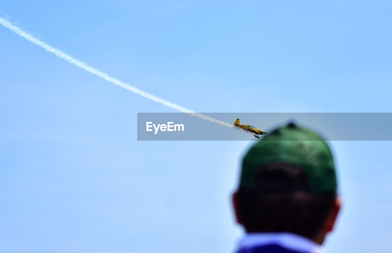 Rear view of man looking at airshow