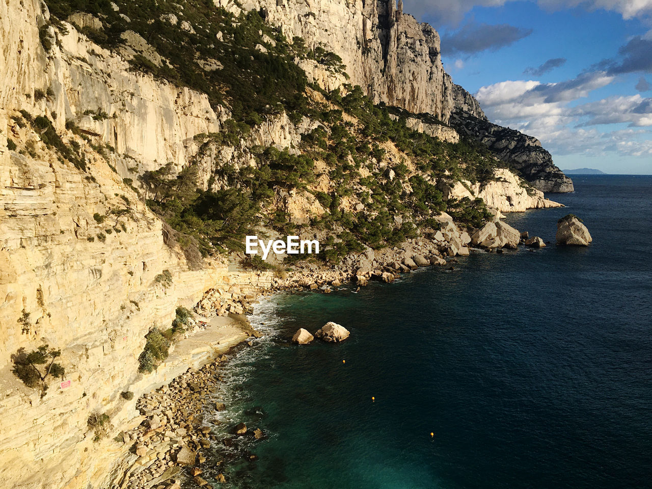 Rock formations by sea against sky