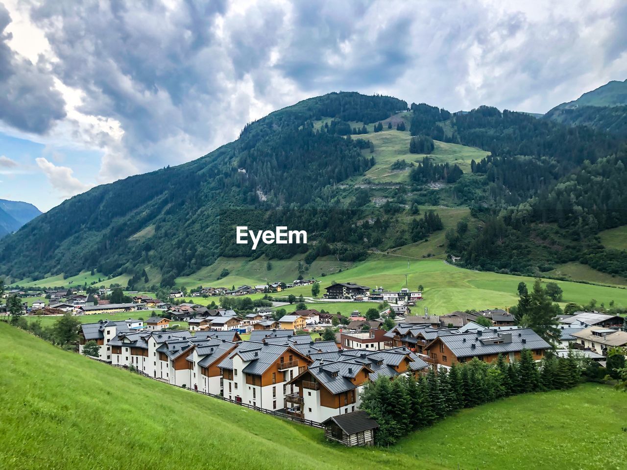 Scenic view of field and buildings against sky