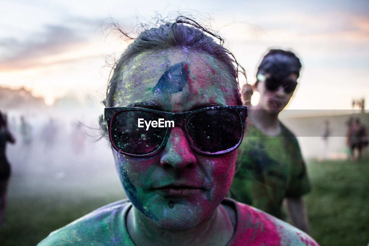 Close-up portrait of woman in sunglasses covered with powder paint