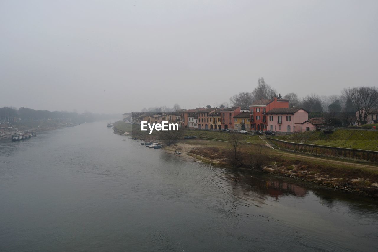 RIVER BY BUILDINGS AGAINST SKY