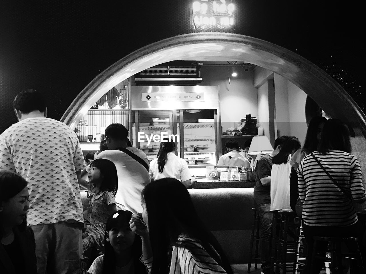 People waiting at restaurant in city at night