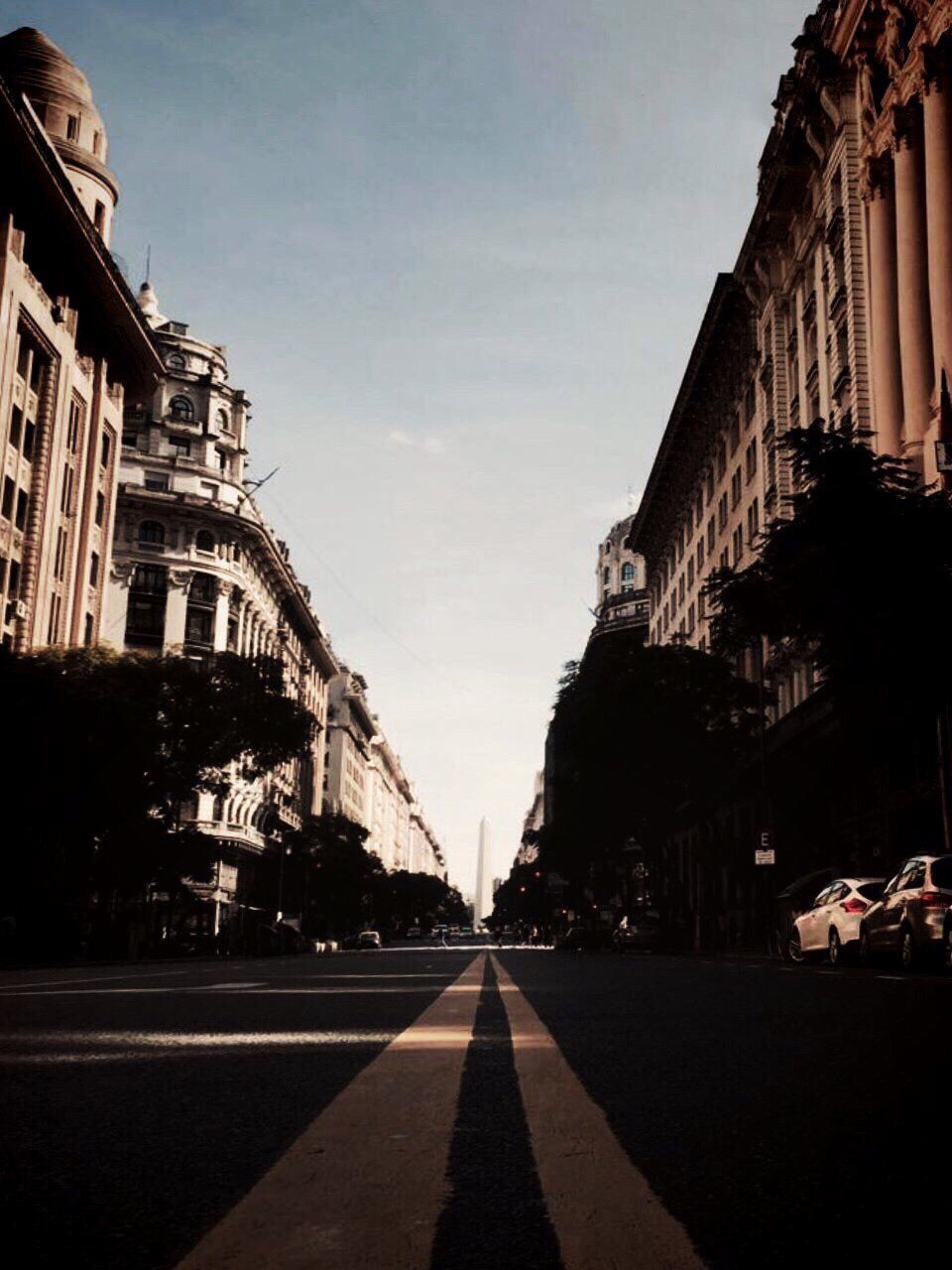 VIEW OF CITY STREET AGAINST CLOUDY SKY