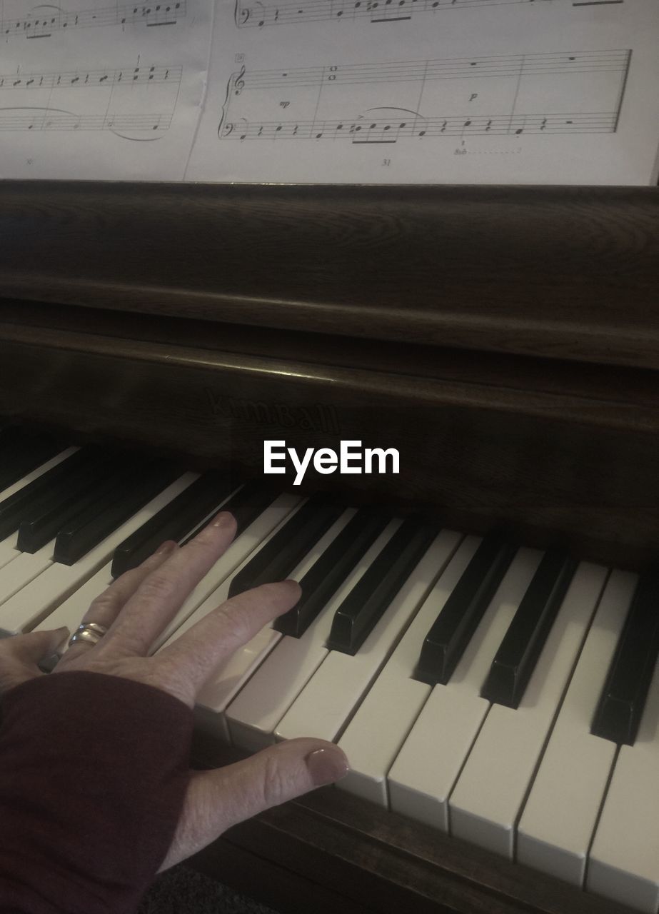 CLOSE-UP OF HAND ON PIANO KEYS