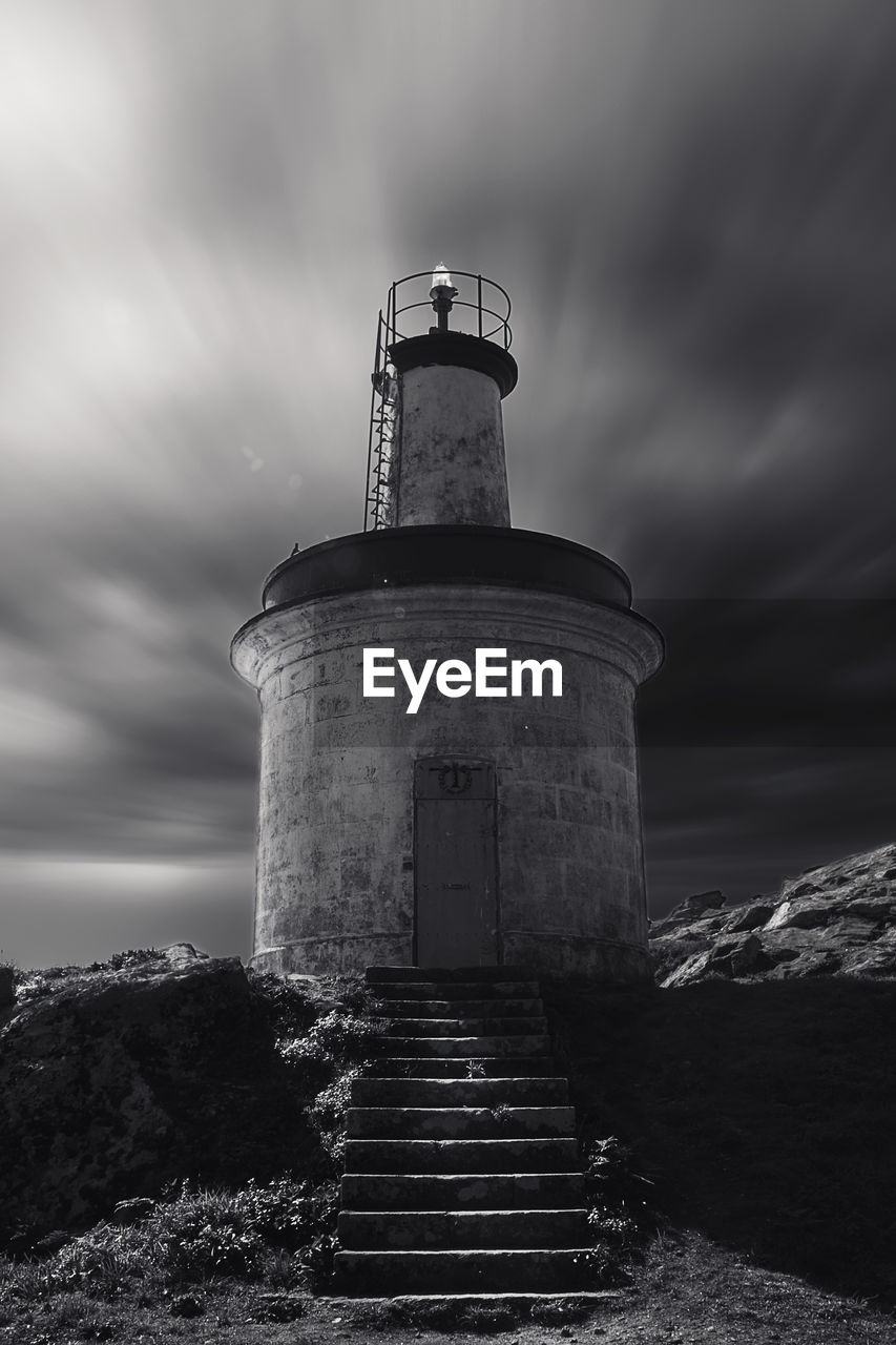 LOW ANGLE VIEW OF LIGHTHOUSE AGAINST BUILDING